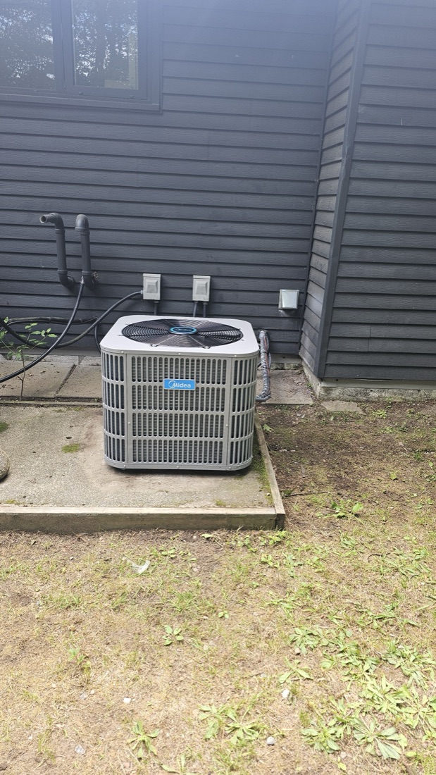 Air conditioning condenser on a pad beside a home